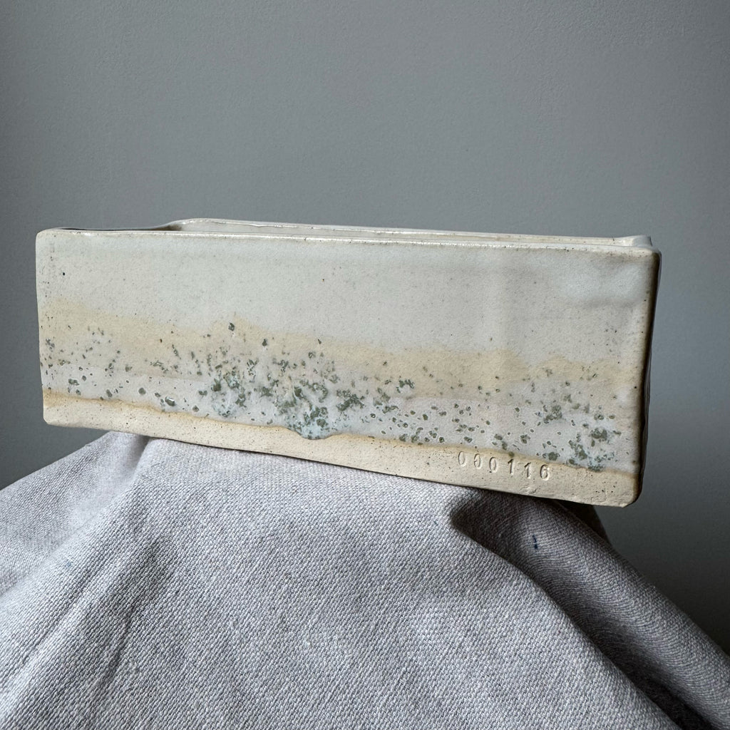 Rectangular ceramic planter with a textured surface on a gray background