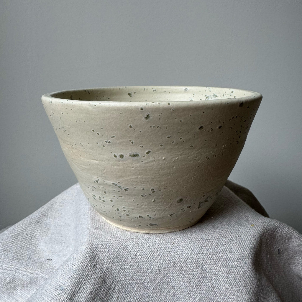 Ceramic bowl on a textured surface with a gray background