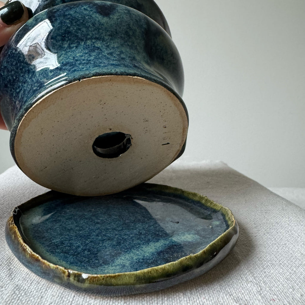 Ceramic container with blue glaze on a light gray surface