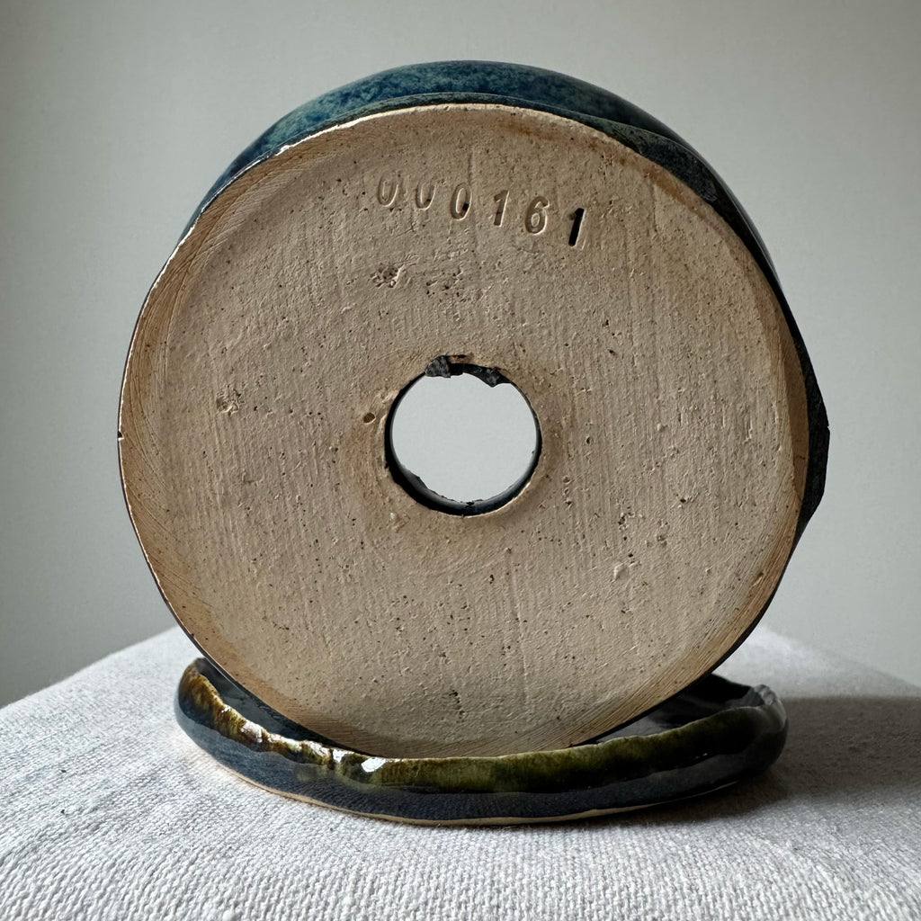 Ceramic spool with a central hole on a textured surface