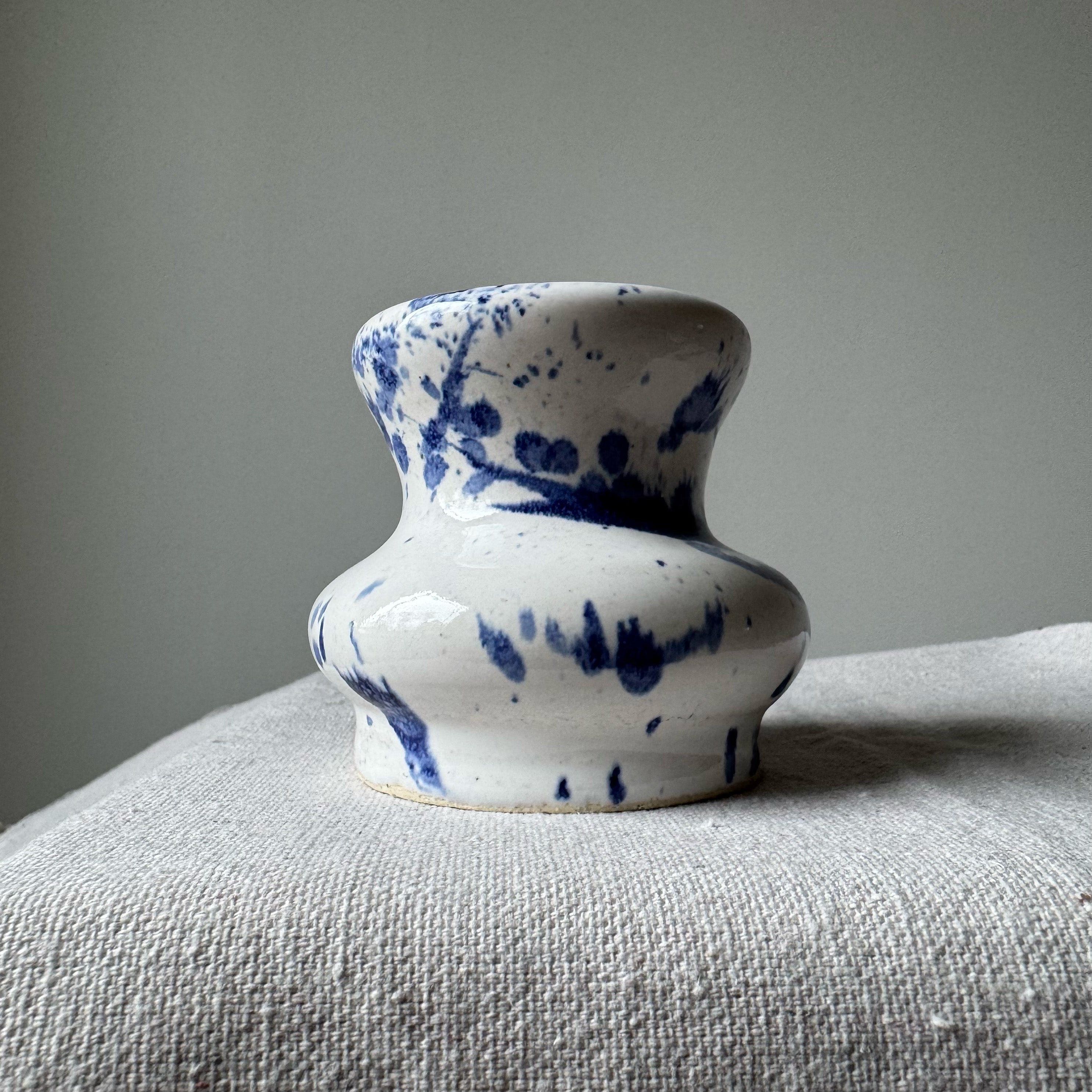 Ceramic vase with blue patterns on a textured surface