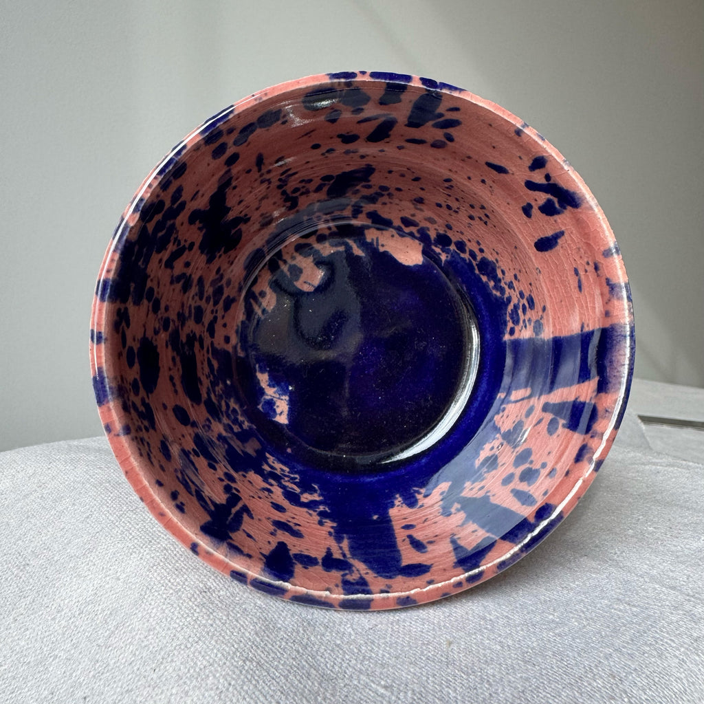 Ceramic bowl with blue and pink abstract design on a gray background