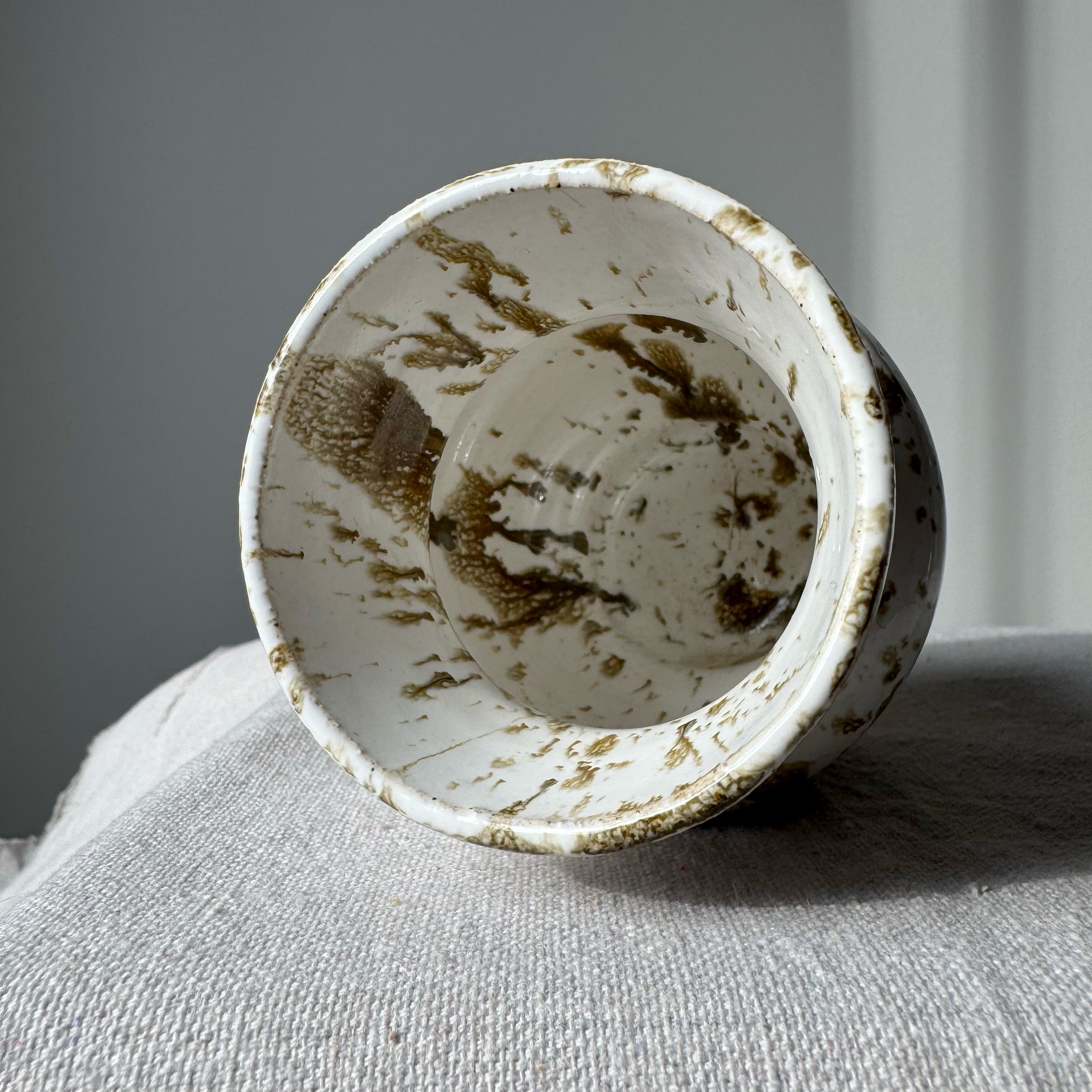 Ceramic bowl with brown speckles on a gray surface