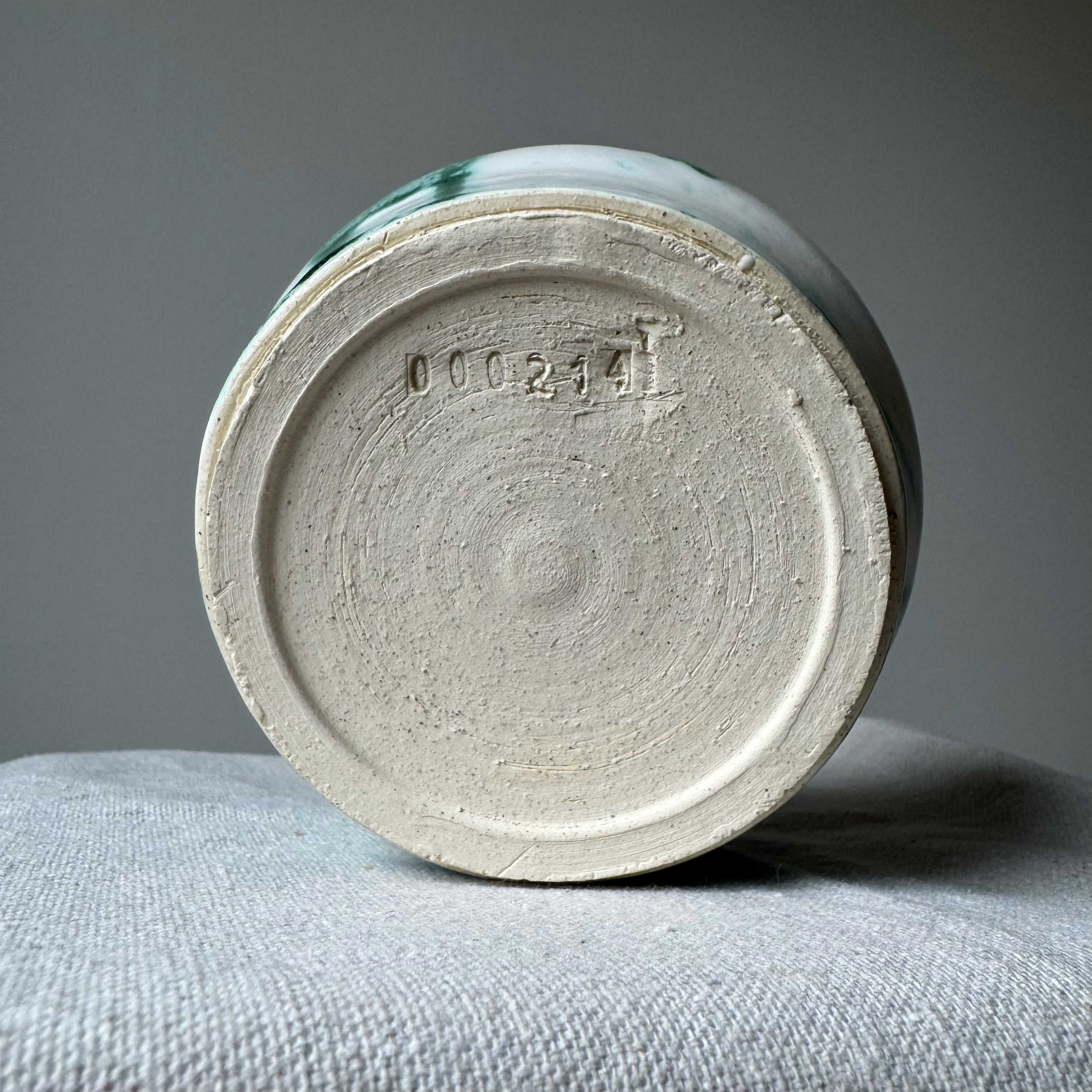 Ceramic vase with a textured base on a gray surface
