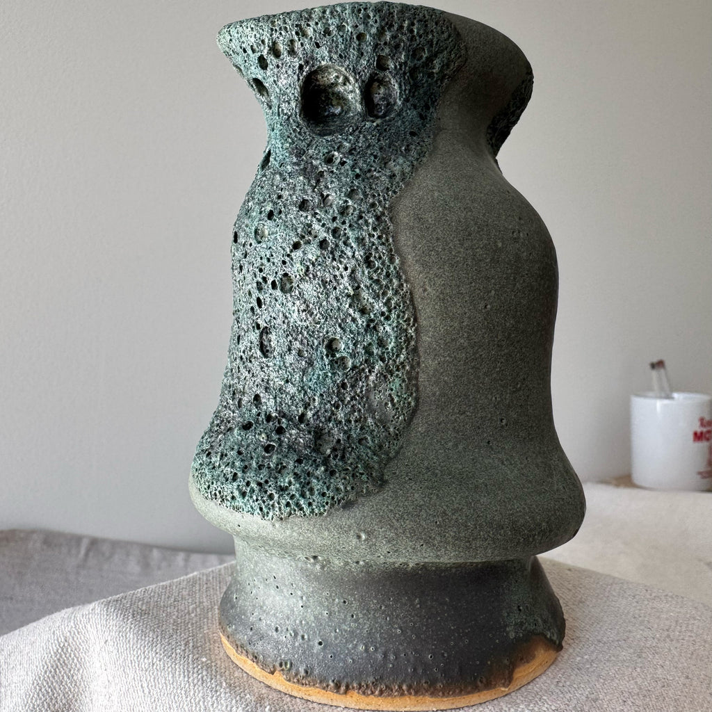 Ceramic vase with textured surface on a neutral background