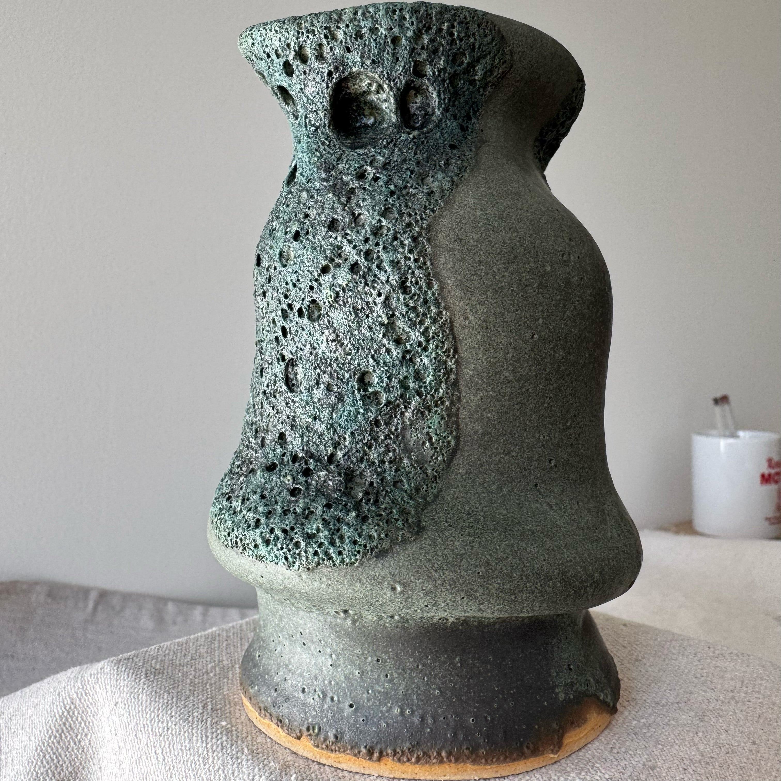 Ceramic vase with textured surface on a neutral background