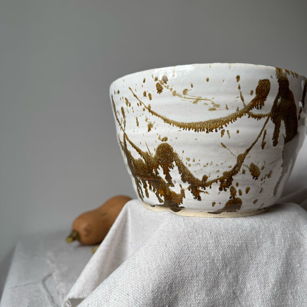Ceramic bowl with brown abstract patterns on a light gray surface