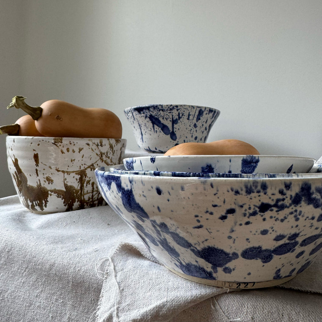 Ceramic bowls with blue and white speckled pattern on a light surface.