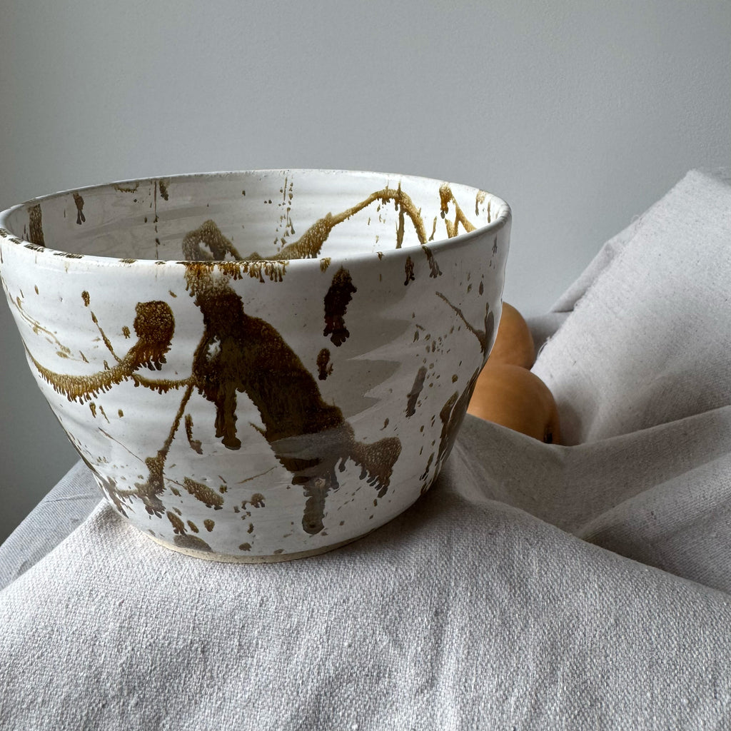 Ceramic bowl with brown abstract design on a white surface