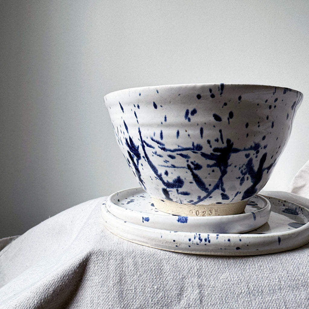 White ceramic bowl with blue abstract patterns on a light gray surface