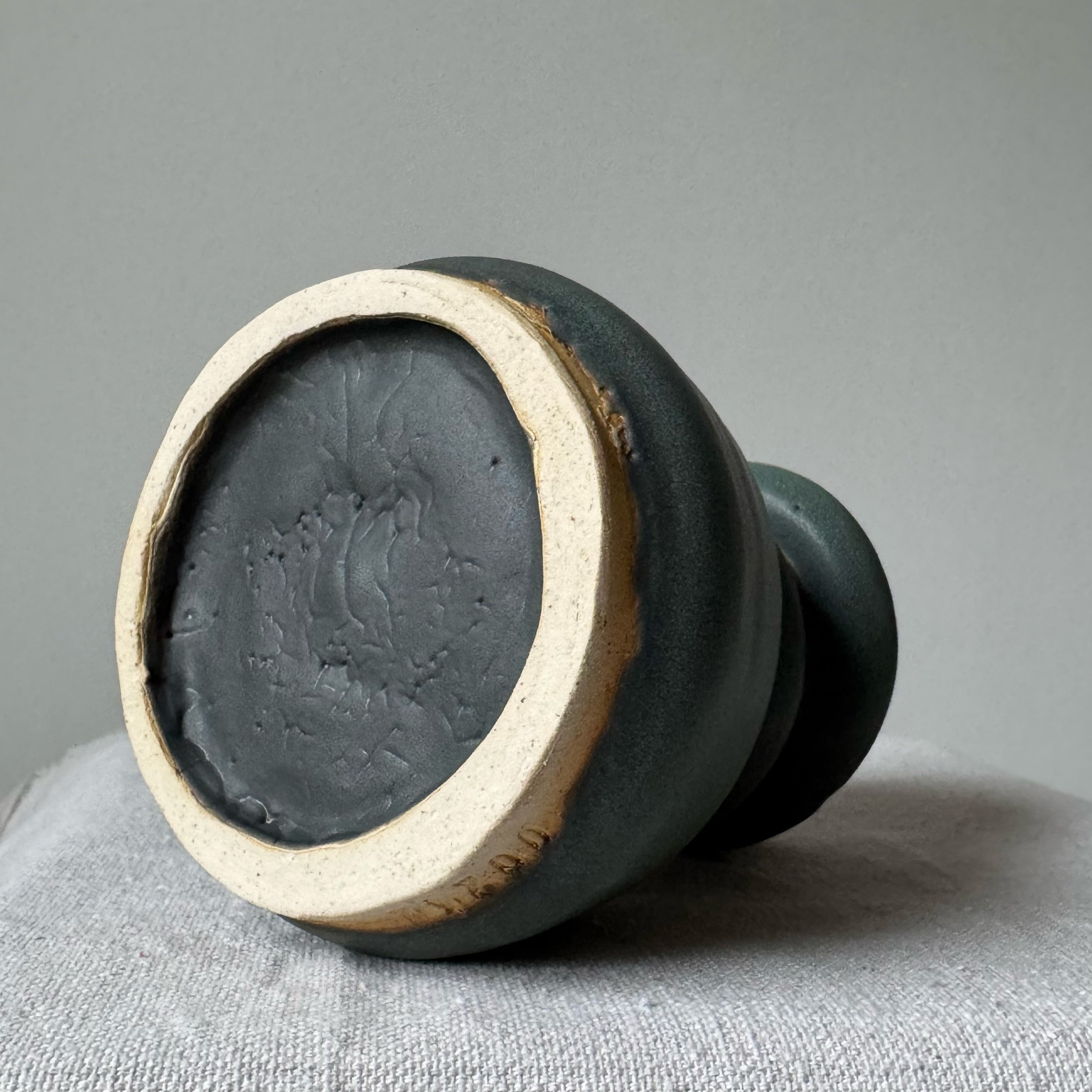 Ceramic vase with textured surface on a gray background