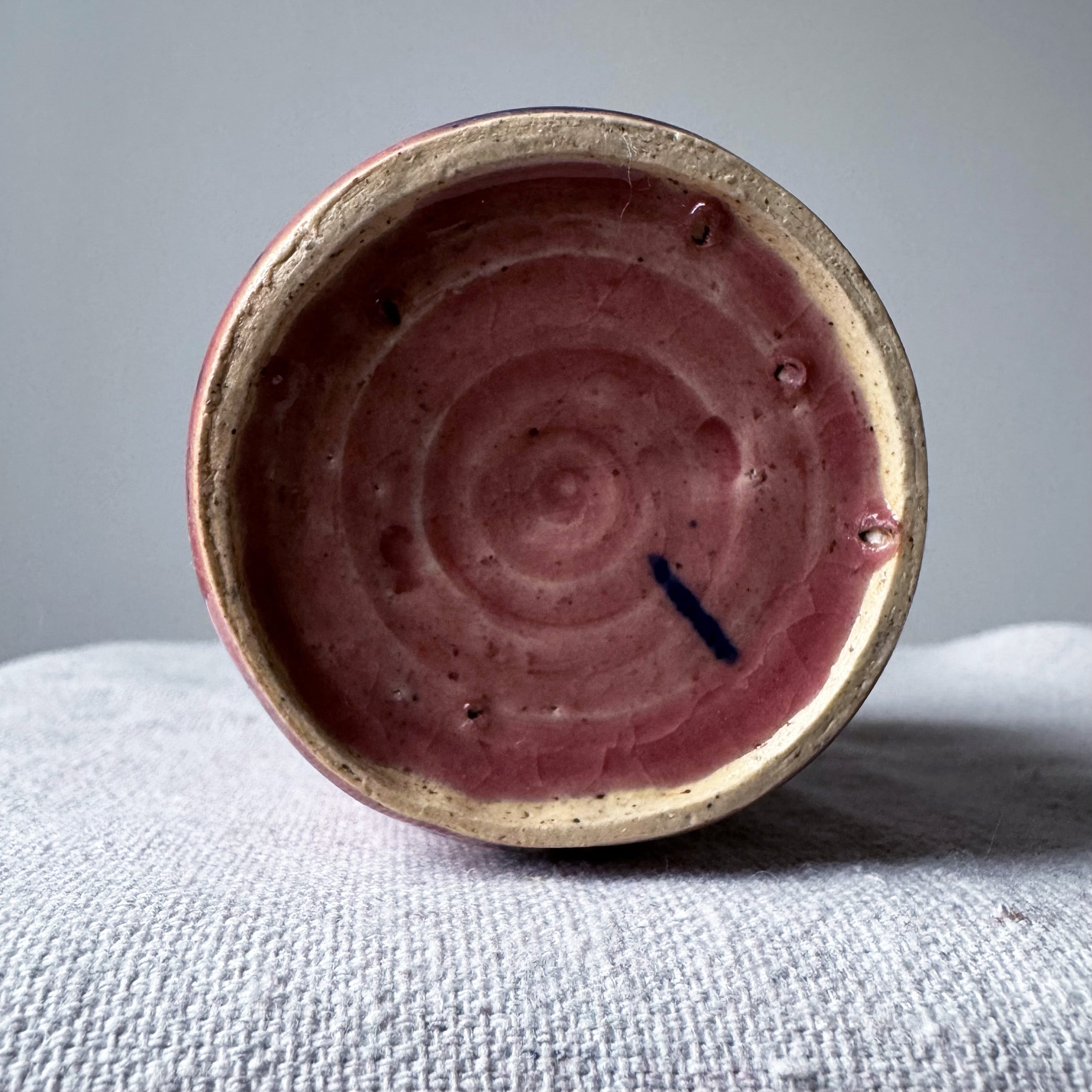 ceramic vase with pink glaze and blue splashes