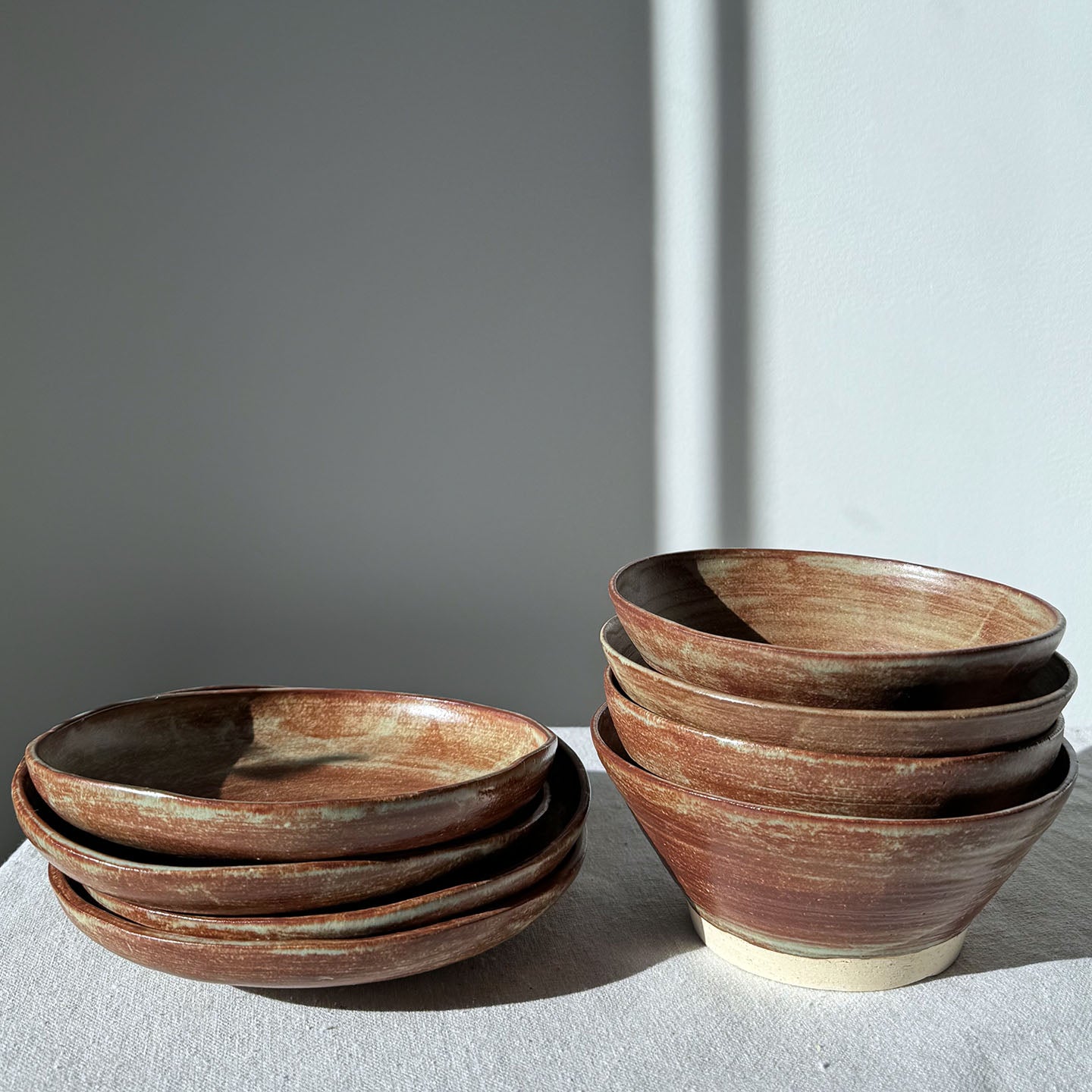 Set of brown ceramic bowls on a light surface with a gray background