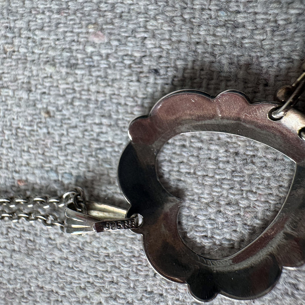 Close-up of a decorative metal object with a scalloped edge on a textured gray background